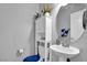 Well-lit bathroom with a pedestal sink, a toilet, and a mirrored cabinet for ample storage at 8456 Blackstone Ridge Ct, Las Vegas, NV 89139