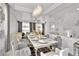 Elegant dining room with a stylish chandelier, sleek marble table, and modern furnishings at 8456 Blackstone Ridge Ct, Las Vegas, NV 89139