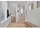 Bright hallway featuring hardwood floors, a staircase with glass railings, and decorative accents at 8456 Blackstone Ridge Ct, Las Vegas, NV 89139