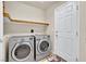 Functional laundry room with modern washer and dryer units and an organizational shelf, making laundry easy at 8456 Blackstone Ridge Ct, Las Vegas, NV 89139