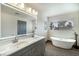 Bright bathroom featuring double sinks, a soaking tub, and contemporary finishes at 9139 Scallop Reef Ave, Las Vegas, NV 89147