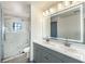 Modern bathroom with double sinks, a large mirror, and a glass-enclosed shower with marble tile at 9139 Scallop Reef Ave, Las Vegas, NV 89147