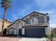 Charming two-story home featuring desert landscaping, a black garage door, and palm tree at 9139 Scallop Reef Ave, Las Vegas, NV 89147