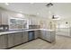 Bright kitchen featuring gray cabinets, stainless steel appliances, a long countertop, and tile floors at 9139 Scallop Reef Ave, Las Vegas, NV 89147