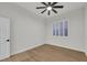 Bright bedroom with a ceiling fan, wood floors, and a large window with white shutters at 9524 Chalgrove Village Ave, Las Vegas, NV 89145