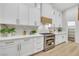 Close-up view of a modern kitchen with white cabinets, stainless steel appliances, and quartz countertops at 9524 Chalgrove Village Ave, Las Vegas, NV 89145