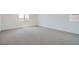 Neutral-colored bedroom with plush carpet, white walls, and a serene atmosphere with natural light from two windows at 9825 Lost Horse Ave, Las Vegas, NV 89178