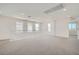 Large bonus room with neutral carpet, bright white walls, and three windows bringing in light at 9825 Lost Horse Ave, Las Vegas, NV 89178