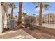 Landscaped backyard with desert vegetation, patio and scenic palm trees for outdoor enjoyment at 10035 Oak Creek Canyon Ave, Las Vegas, NV 89147