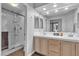 Bright bathroom with a double sink vanity, framed mirror, and glass-enclosed shower at 10035 Oak Creek Canyon Ave, Las Vegas, NV 89147