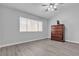 Bedroom featuring wood-style floors, neutral walls, a large window, and dark-stained dresser at 10035 Oak Creek Canyon Ave, Las Vegas, NV 89147