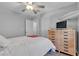 Inviting bedroom features a ceiling fan, natural wood dresser, and modern decor at 10035 Oak Creek Canyon Ave, Las Vegas, NV 89147