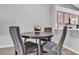 Cozy dining area featuring a round wooden table and upholstered chairs with kitchen view at 10035 Oak Creek Canyon Ave, Las Vegas, NV 89147