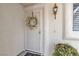 Elegant front door with decorative wreath and a wall-mounted light fixture at 10035 Oak Creek Canyon Ave, Las Vegas, NV 89147