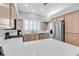 Bright kitchen featuring stainless steel appliances, wood cabinets, and a tiled countertop at 10035 Oak Creek Canyon Ave, Las Vegas, NV 89147