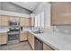 Bright kitchen featuring stainless steel appliances, wood cabinets, and a tiled countertop at 10035 Oak Creek Canyon Ave, Las Vegas, NV 89147