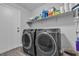 Functional laundry room features modern gray washer and dryer, with storage shelves at 10035 Oak Creek Canyon Ave, Las Vegas, NV 89147