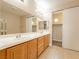 Well-lit bathroom with double sinks, a large mirror and a walk in closet at 10051 Sand Key St, Las Vegas, NV 89178