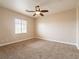 Spacious carpeted bedroom featuring a ceiling fan and a window for natural light at 10051 Sand Key St, Las Vegas, NV 89178