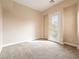 This bedroom features neutral walls and carpet, base molding, and a glass paned door to the outside at 10051 Sand Key St, Las Vegas, NV 89178