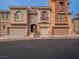 View of the townhome-style condos featuring multiple-car garages and a well-maintained exterior at 10051 Sand Key St, Las Vegas, NV 89178