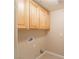 This laundry room features light wood upper cabinets, tan walls, and tiled floors at 10051 Sand Key St, Las Vegas, NV 89178