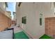 Side view of a cozy backyard featuring brick pavers, artificial turf, and a building exterior at 10722 Red Badge Ave, Las Vegas, NV 89166