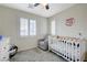 Charming bedroom features gray carpet, a crib, plantation shutters, ceiling fan and a cozy gray chair at 10722 Red Badge Ave, Las Vegas, NV 89166