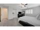 Airy main bedroom featuring gray carpet, plantation shutters, a ceiling fan, and an ensuite bathroom at 10722 Red Badge Ave, Las Vegas, NV 89166