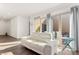 Cozy living room with a white leather sofa, tiled flooring, and sliding doors leading to the outdoor space at 10879 Artesano Ave, Las Vegas, NV 89135