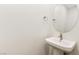 Modern powder room featuring a pedestal sink, round mirror, and minimalist design at 10879 Artesano Ave, Las Vegas, NV 89135