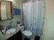 Compact bathroom featuring vanity, toilet, and shower with grab bar and patterned curtain at 110 Palm Ln, Las Vegas, NV 89101