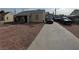 Front view of the property with parking on a long driveway and desert landscaping at 110 Palm Ln, Las Vegas, NV 89101