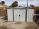 View of the utility shed in the backyard with a closed white door and handle at 110 Palm Ln, Las Vegas, NV 89101