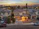 Stunning aerial view of a two-story home with a balcony against a vibrant sunset backdrop at 1309 Rainy Sky Ave, North Las Vegas, NV 89030