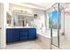 Bright bathroom features a soaking tub, separate shower, and blue vanity with double sinks at 1309 Rainy Sky Ave, North Las Vegas, NV 89030