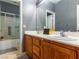 Bathroom featuring wood cabinets, laminate counters, large mirror, and shower at 1309 Rainy Sky Ave, North Las Vegas, NV 89030