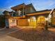 Inviting two-story home with a balcony, stone accents, and warm exterior lighting at dusk at 1309 Rainy Sky Ave, North Las Vegas, NV 89030