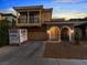 Lovely two-story home with a balcony, stone accents, and a well-manicured front yard at twilight at 1309 Rainy Sky Ave, North Las Vegas, NV 89030
