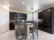 Kitchen with dark cabinetry, stainless steel appliances, breakfast bar, and ample counter space at 1309 Rainy Sky Ave, North Las Vegas, NV 89030