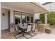 Spacious covered back patio with a large table, built-in grill, and stone accents at 2001 Alcova Ridge Dr, Las Vegas, NV 89135
