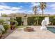 Inviting backyard fire pit with stone surround, palm trees, and manicured landscaping at 2001 Alcova Ridge Dr, Las Vegas, NV 89135