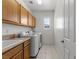 Well-lit laundry room with built-in cabinets, sink, and modern washer and dryer at 2001 Alcova Ridge Dr, Las Vegas, NV 89135