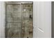 Glass enclosed marble shower with rainfall head, shelving and a shower door at 2001 Alcova Ridge Dr, Las Vegas, NV 89135