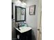 Compact bathroom with a sleek black vanity, toilet paper storage, and flamingo wall art at 228 E Van Wagenen St, Henderson, NV 89015