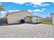 Spacious backyard with a covered patio, synthetic grass, and large paved area at 2419 Country Orchard St, North Las Vegas, NV 89030