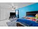 A colorful bedroom features a ceiling fan, blue accent wall, and tile flooring at 2419 Country Orchard St, North Las Vegas, NV 89030