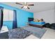 A colorful bedroom features a ceiling fan, blue accent wall and area rug at 2419 Country Orchard St, North Las Vegas, NV 89030