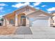 Charming single-story home featuring a well-maintained lawn, two-car garage, and inviting covered front porch at 2419 Country Orchard St, North Las Vegas, NV 89030