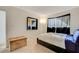 Bedroom with a leather platform bed, wood accent wall, and bright, neutral carpet at 3821 1/2 Daisy St # 25, Las Vegas, NV 89119